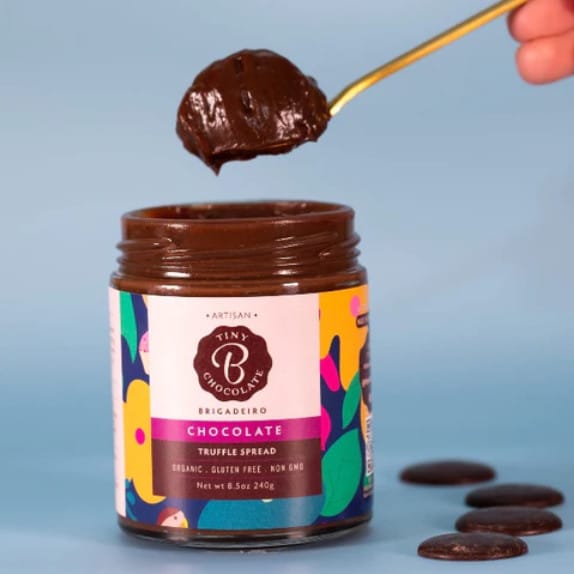 spoon with dark chocolate truffle spread lifting from jar